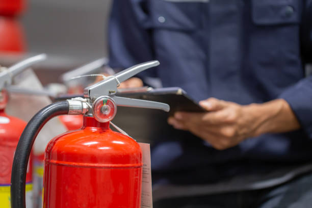 Un ingénieur check et inspecte un extincteur - Utilisations des extincteurs