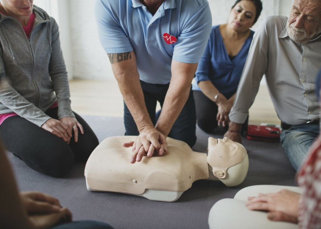 Formateur fait un massage cardiaque à un mannequin - Formation PSC 1